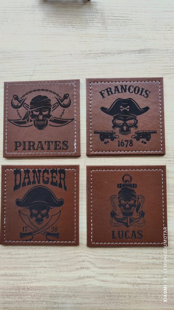 Sous-verres en cuir PU marron de 10 cm avec gravures laser : motifs de pirate, nom 'FRANÇOIS', signal 'DANGER', et prénom 'LUCAS', bordures chaînées et coutures blanches