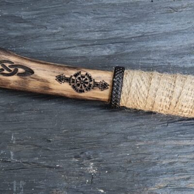 Hache viking artisanale avec lame gravée en acier forgé et manche en bois sculpté, ornée de motifs nordiques et d’un enroulement de corde naturelle.
