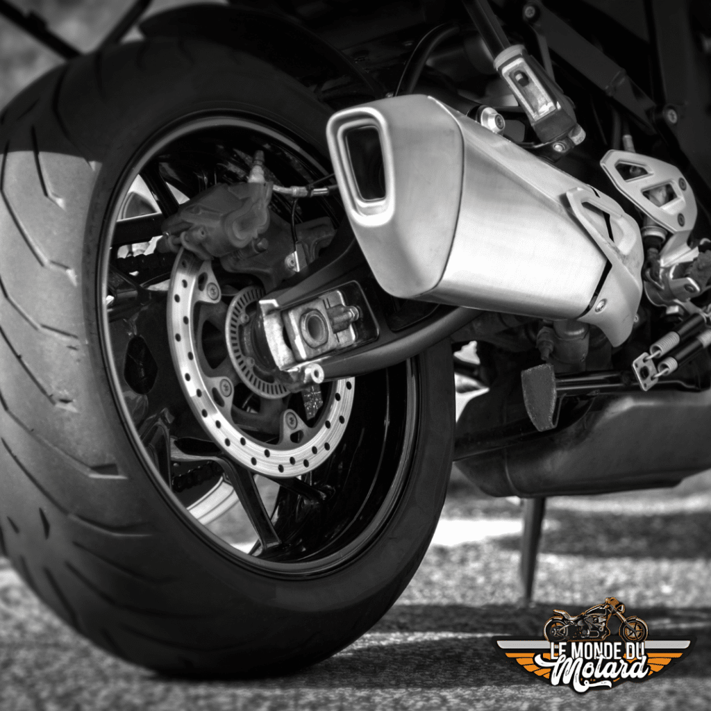 Pot d'échappement et roue arrière d'une moto, illustrant la puissance sonore des motos - Le Monde du Motard.