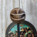 Porte-casque mural Smiley fun avec boule sculptée Smiley grimaçant et plaque métallique Motorcycle Garage interchangeable