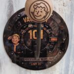 Porte casque Fallout mural Unite 07 rond 35 cm avec support sur tige et boule en bois gravee